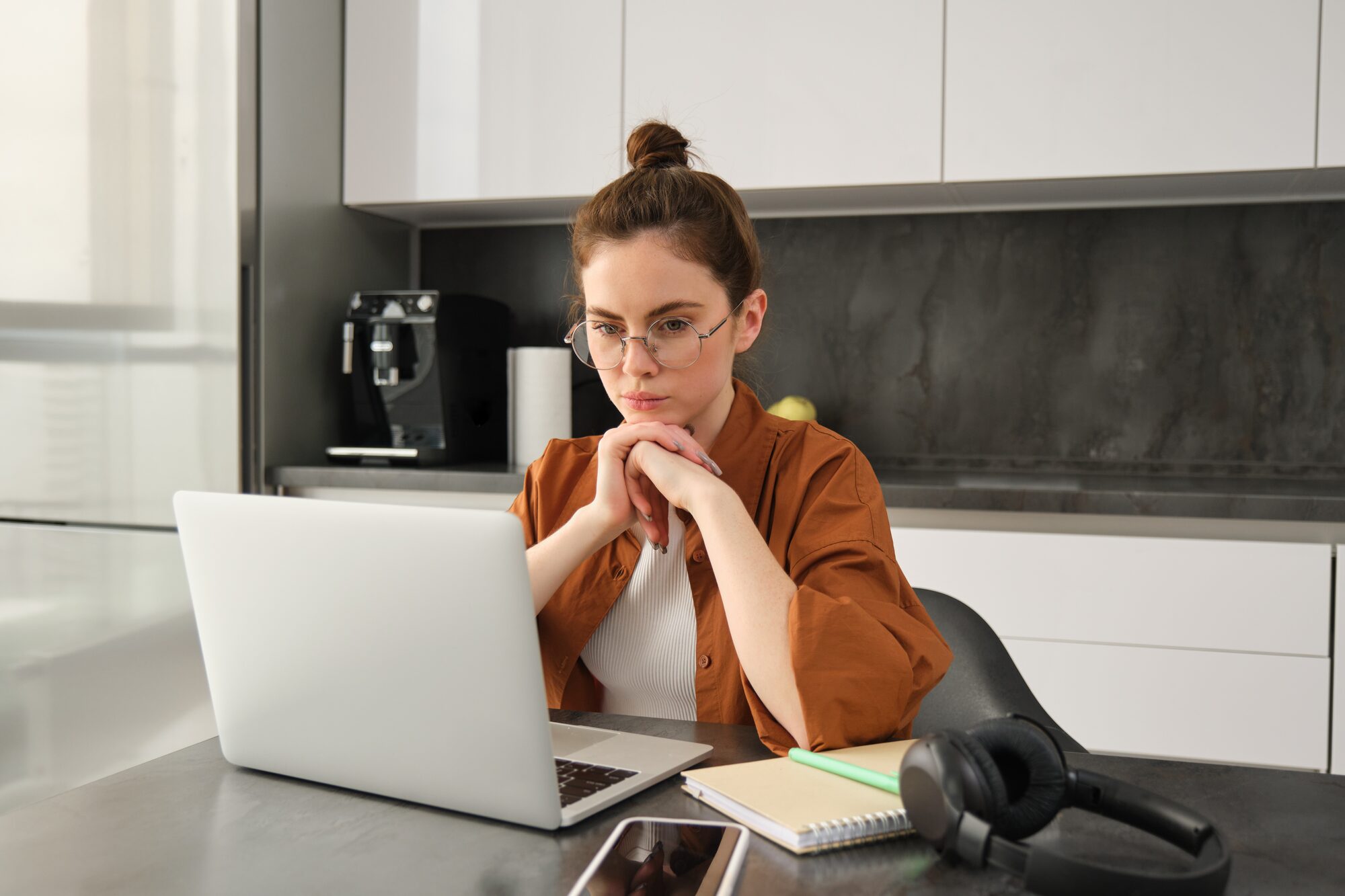 Self-employed woman working on a laptop at her kitchen table