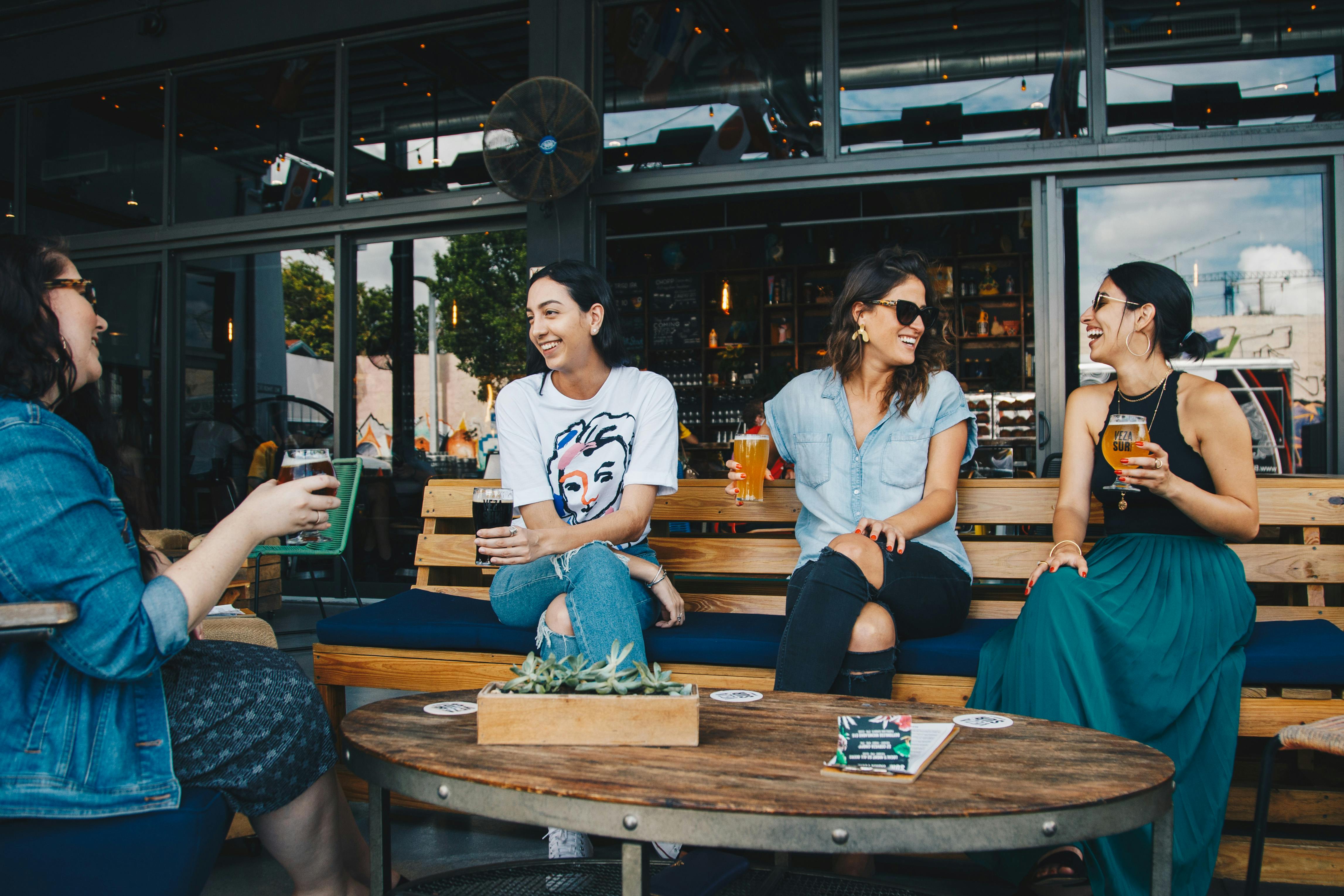 Women chatting outdoors with drinks stock image