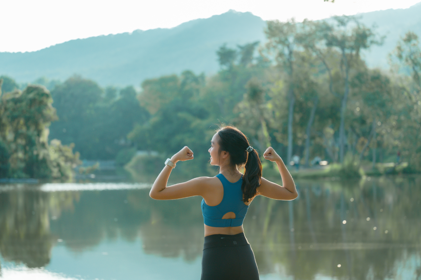 Woman flexing by lake stock image