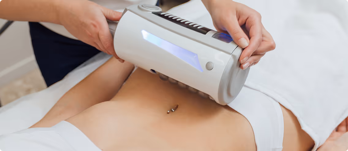 Close-up of a person receiving a body contouring treatment with a handheld device on the abdomen.