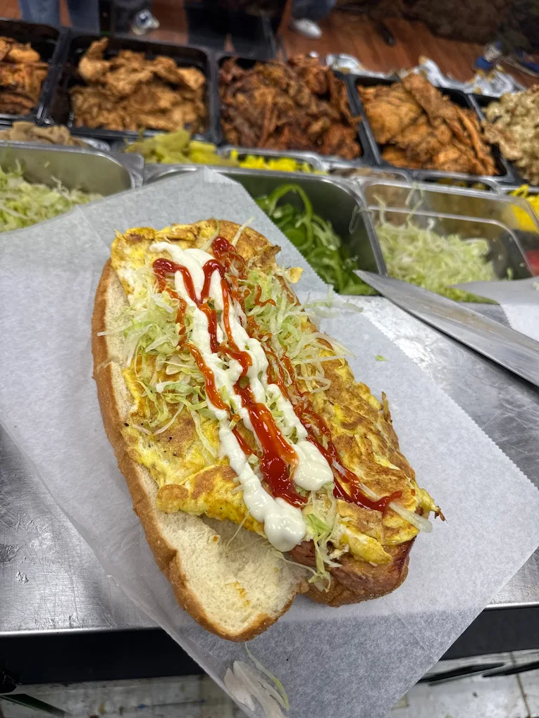 A hot dog with mustard, guacamole, and ketchup
