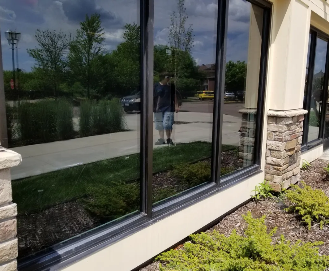 Close-up of professional glass restoration tools removing oxidation from a window pane.