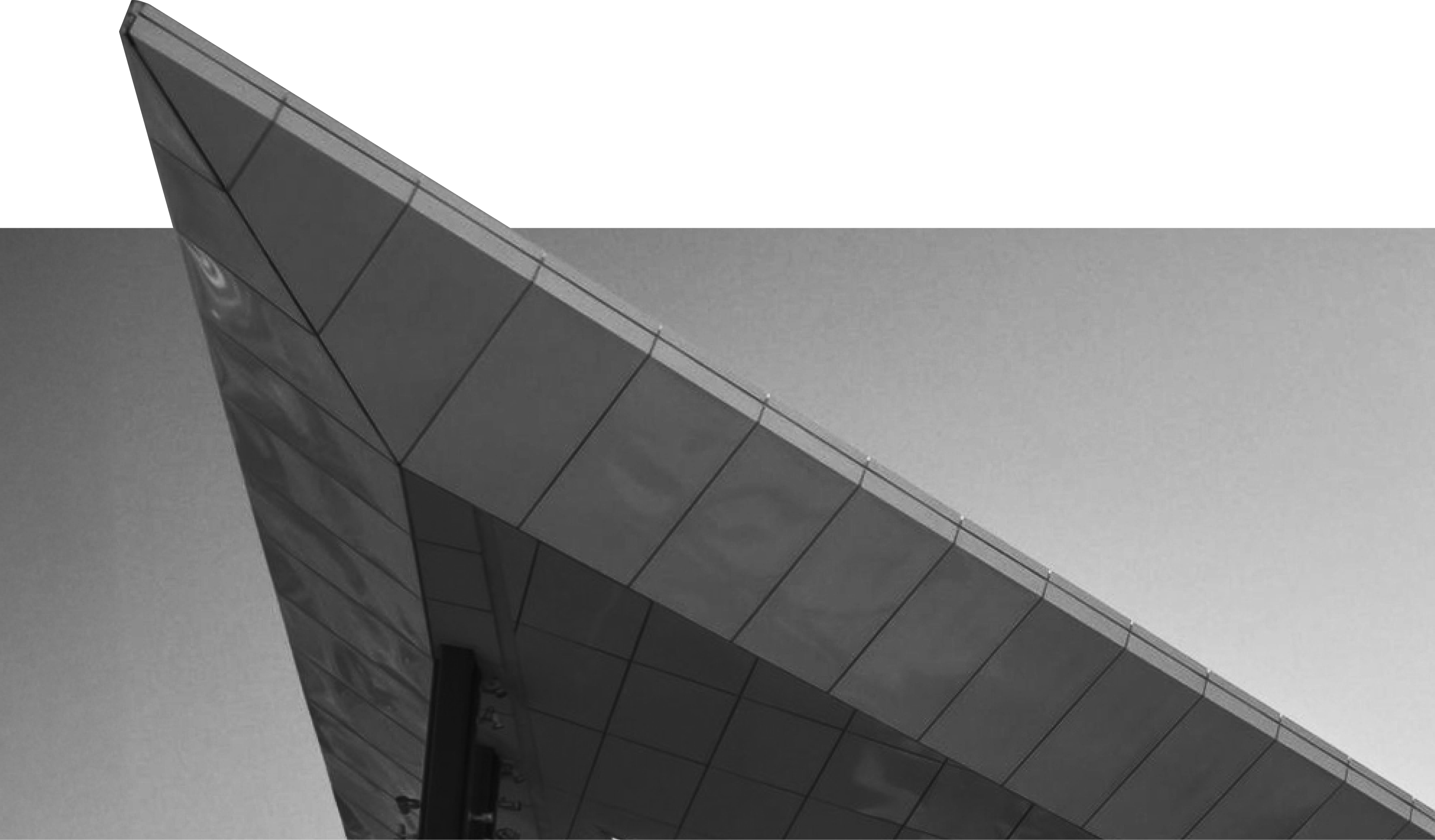 Sharp triangular modern metal roof structure against a clear sky.