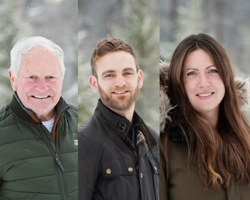 Three people outdoors in winter jackets, smiling with a snowy background.