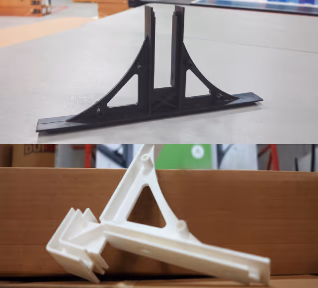 Two plastic corner brackets, one black standing upright and one white lying on its side on a box.