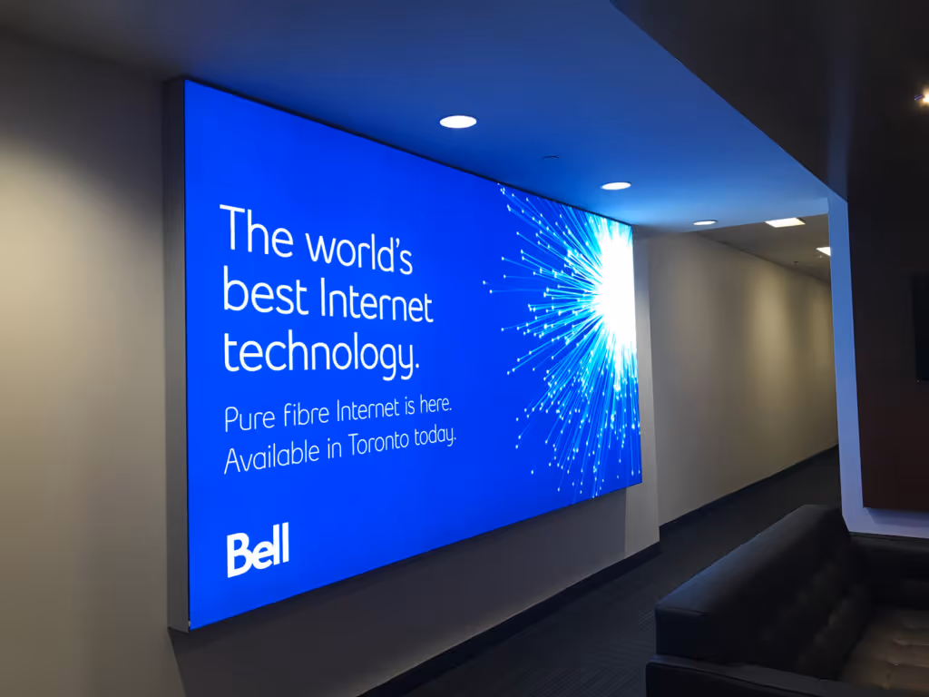 Wall-mounted lightbox with blue background displaying text about Bell's best Internet technology and pure fibre Internet available in Toronto.