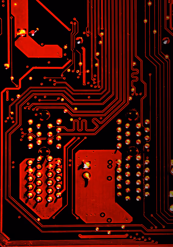 Close-up of a red and black printed circuit board showing intricate copper traces and solder points.