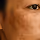 Close-up of a person's eye and surrounding skin showing texture and wrinkles.