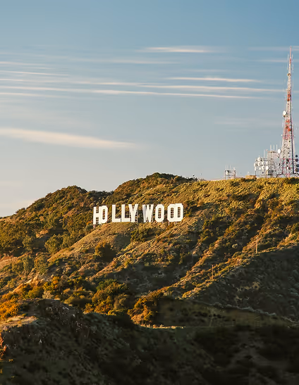 Hollywood sign on a hillside under a clear sky with communication towers nearby.