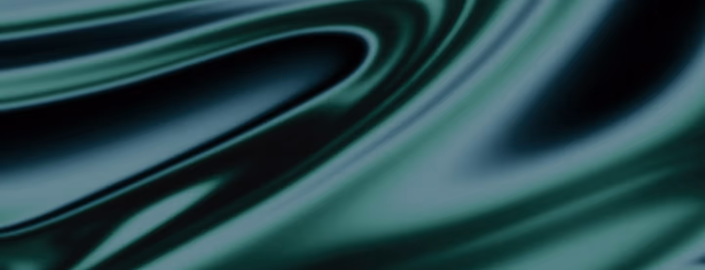 Close-up of dark green silky fabric with smooth folds and soft sheen.