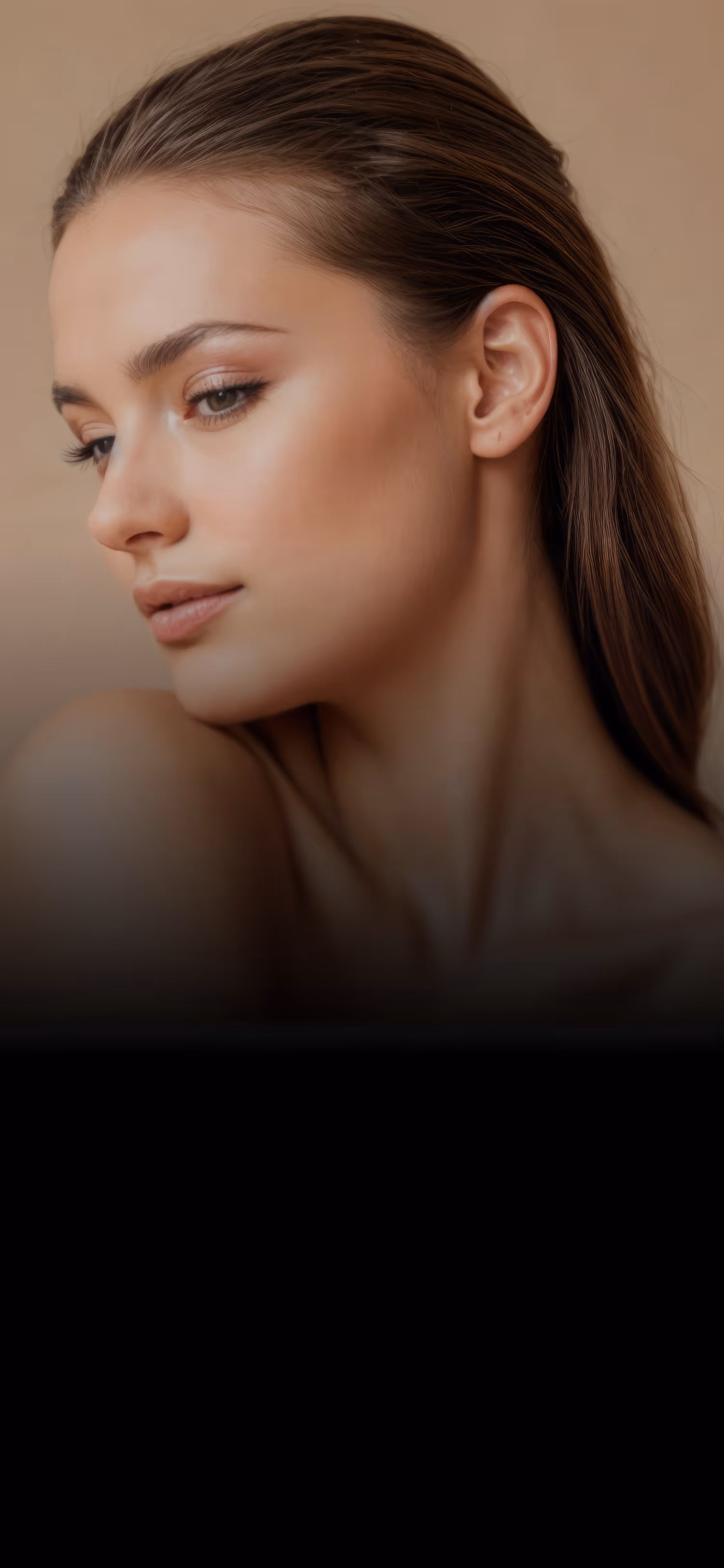 Close-up of a woman with smooth skin looking downward against a beige background.