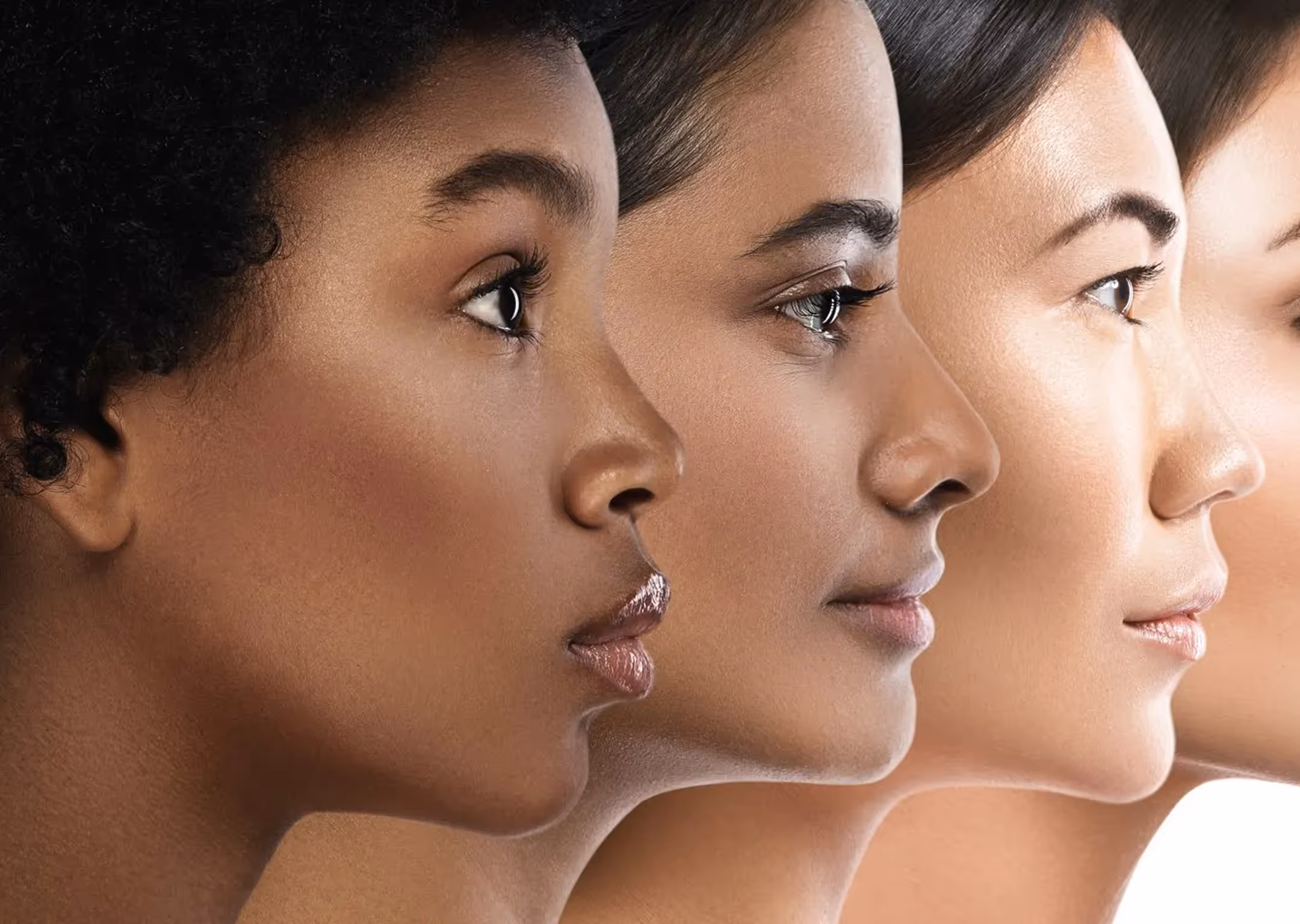 Four diverse women lined up side by side showing different skin tones in profile view.
