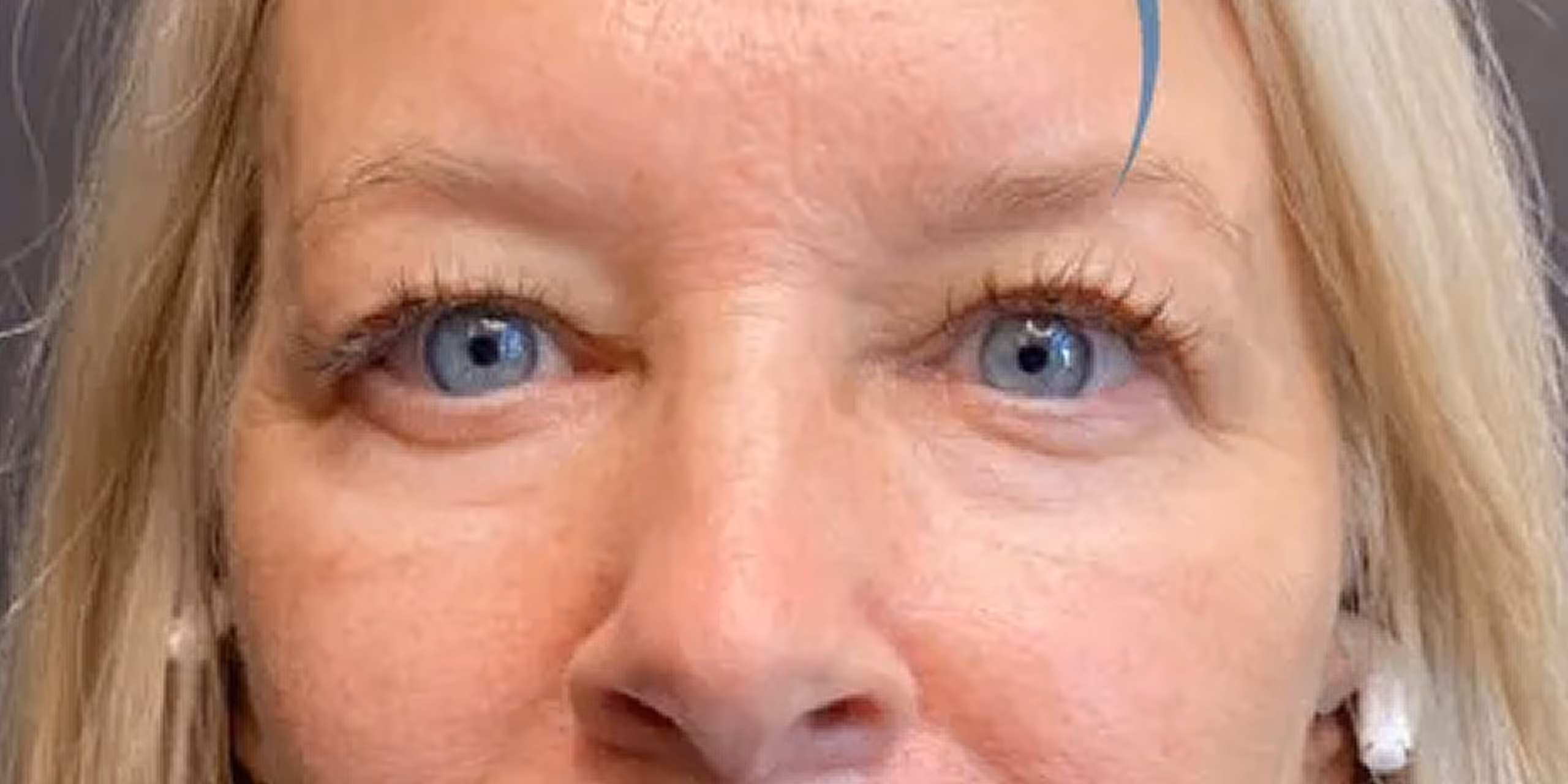 Close-up of a woman’s face focused on blue eyes and light blonde hair.