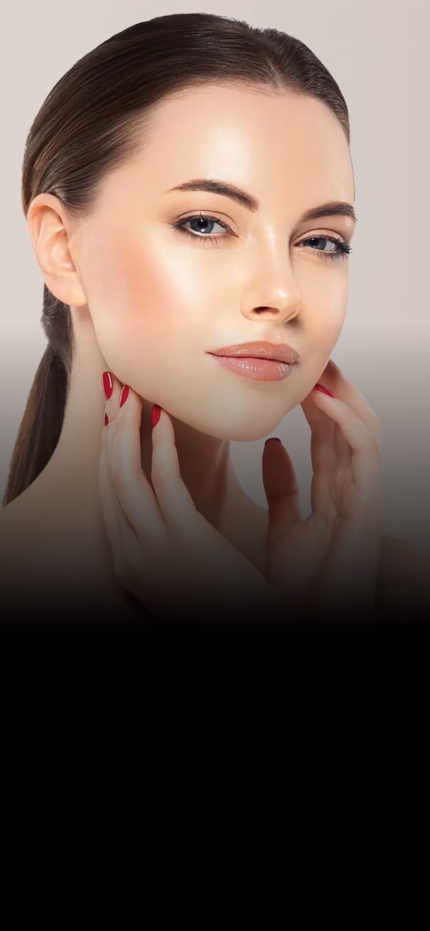 Close-up of a woman with clear skin, minimal makeup, red nail polish, and slicked-back hair.