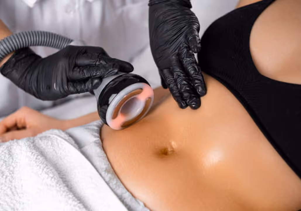 Close-up of a person receiving a black-gloved technician's ultrasound or laser treatment on their abdomen.