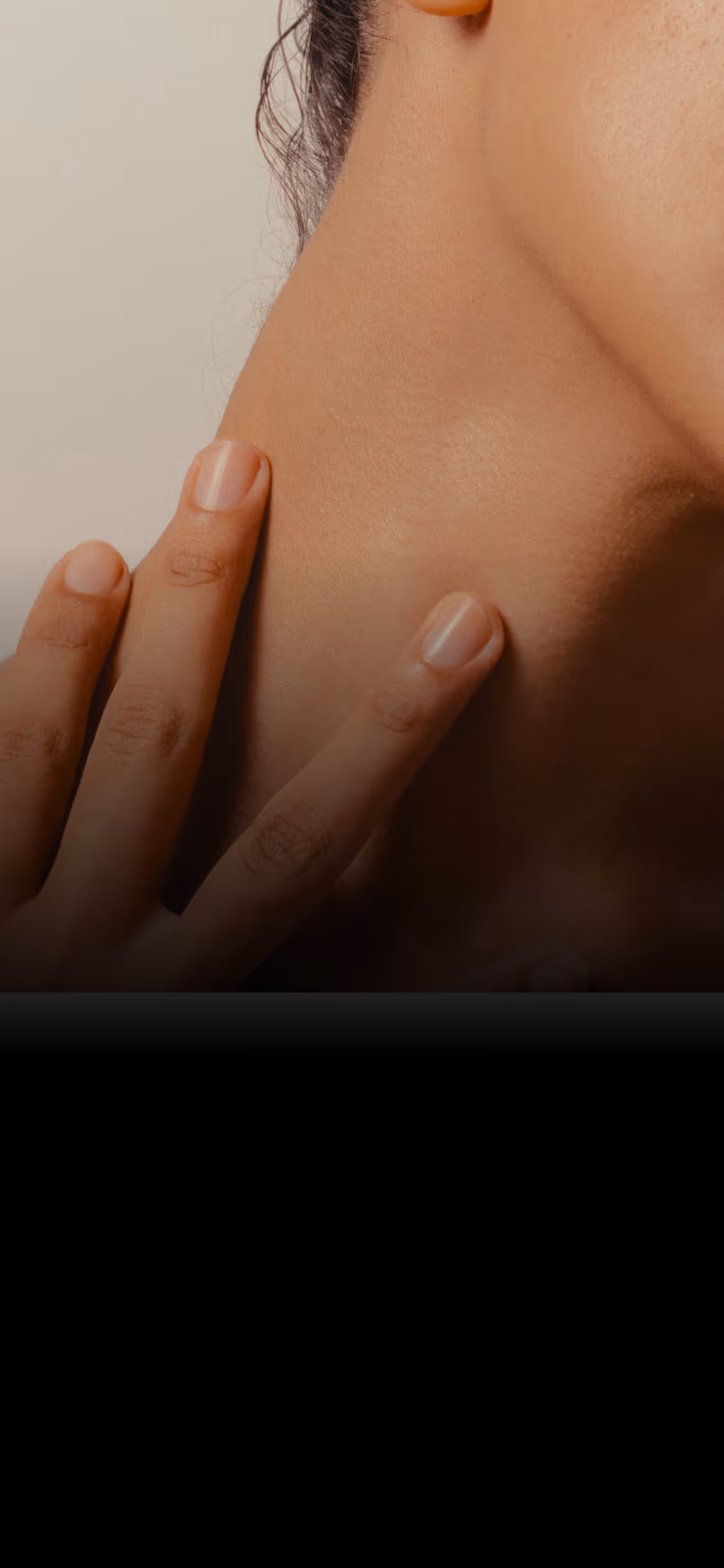 Close-up of hand gently touching the back of a person's neck with smooth skin.