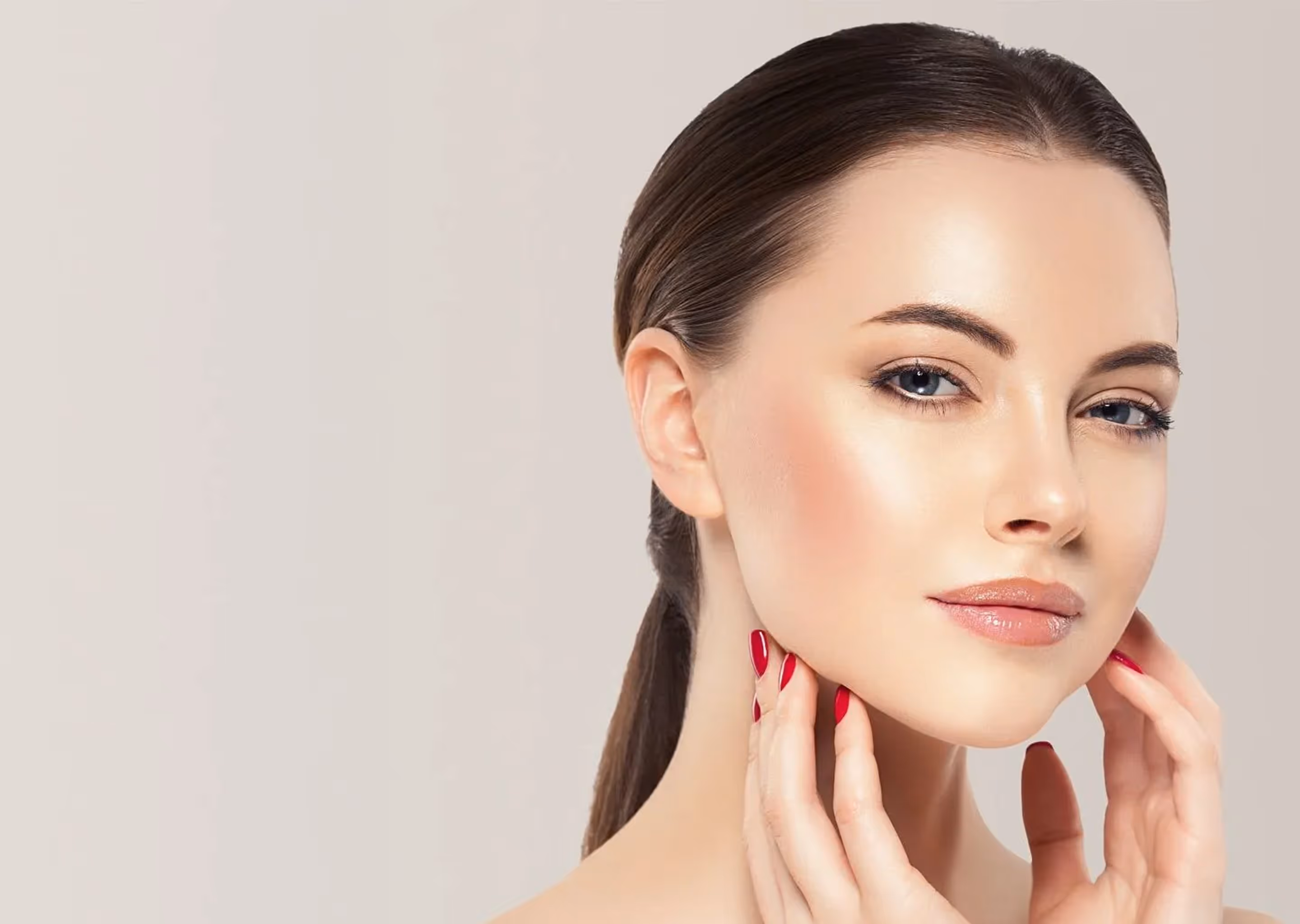 Woman with clear skin touching her neck, showcasing smooth complexion and red nail polish.