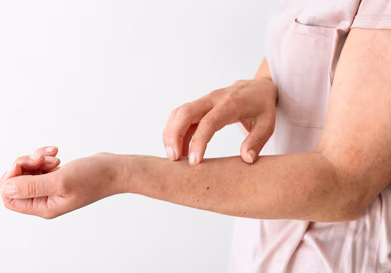 Person scratching the inside of their left forearm with their right hand fingers.