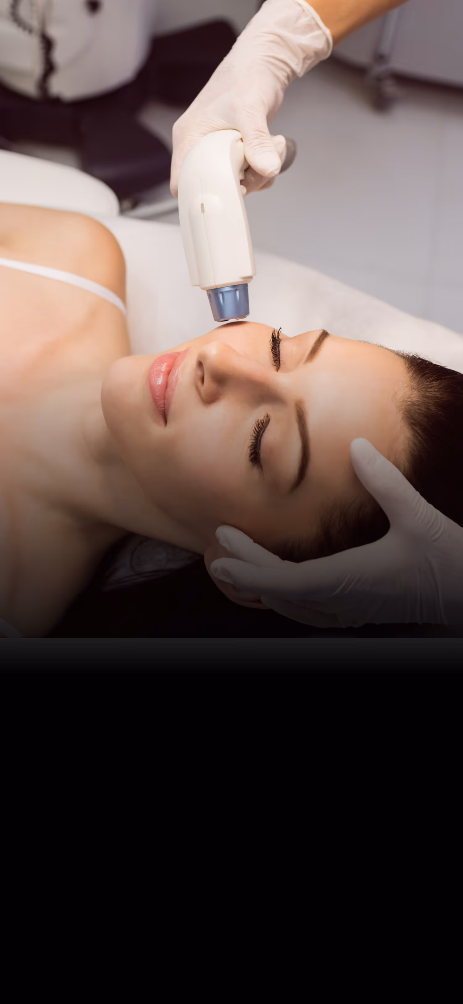 Woman receives a facial laser treatment from a technician wearing gloves.