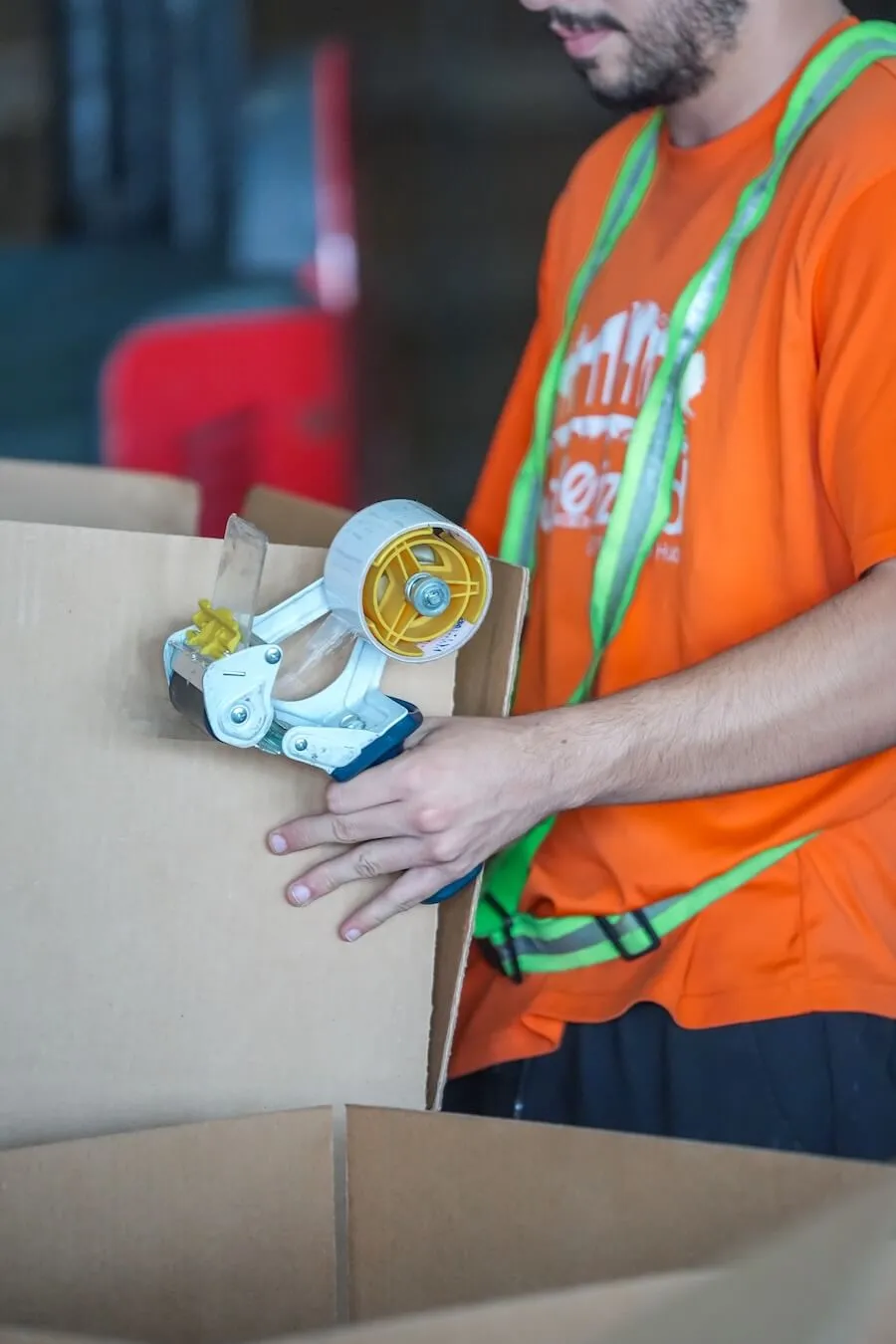 Warehouse worker sealing a box with packing tape