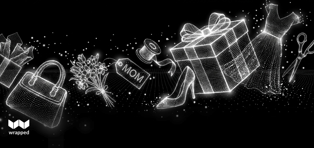 A wrapped fashion gift with a handwritten note sitting on a spring tabletop with flowers nearby