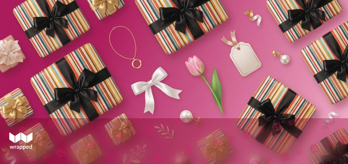 A delicate necklace in a gift box surrounded by spring flowers and a handwritten card