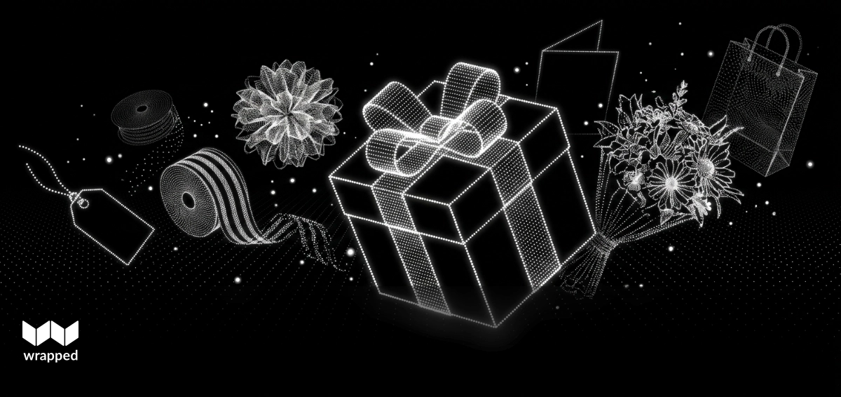 A wrapped book gift beside a bracelet and gift box on a table with warm spring light