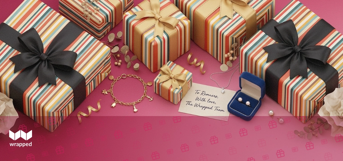 A gold charm bracelet, silver necklace, pearl earrings and a handwritten card arranged beside an open velvet jewelry box