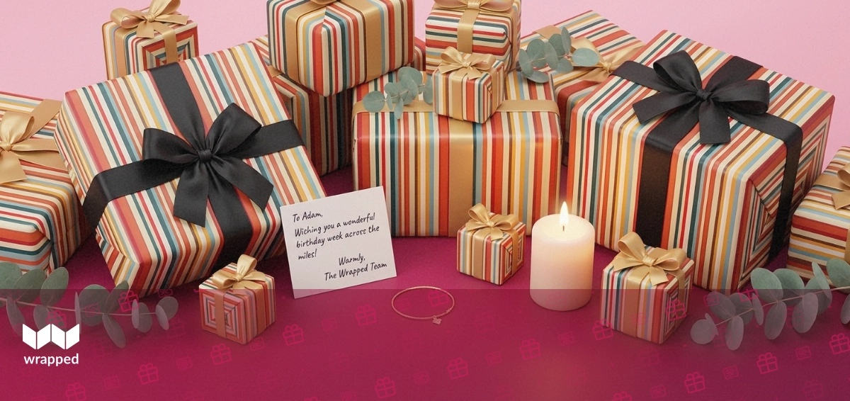 Warm rose-lit tabletop with a handwritten card, gold bracelet, lit candle, ribboned gift box and eucalyptus sprig