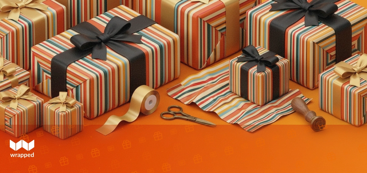 Striped gift box with satin ribbon, patterned wrapping paper, brass scissors and a wax seal on a warm amber surface