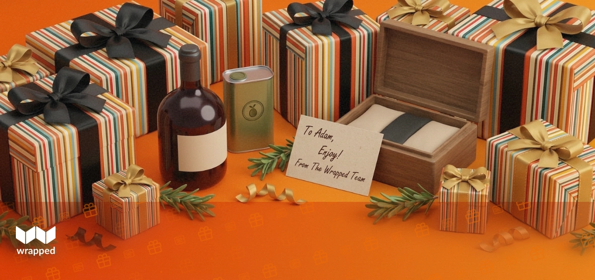 A wine bottle, olive oil tin and wooden gift box packed with rosemary and a handwritten card on a warm amber table