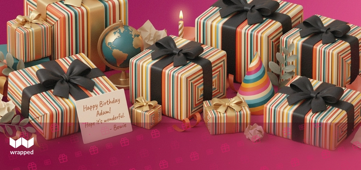 A birthday candle, small brass globe, party hat, wrapped gift box and handwritten card arranged on a bright table