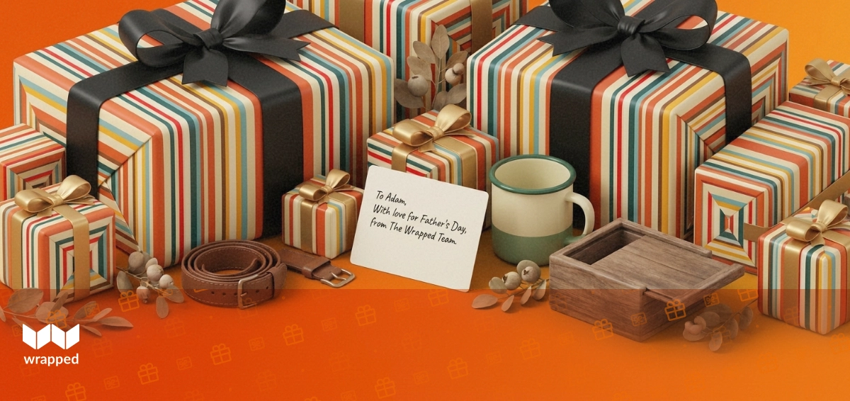 A leather watch strap, enamel mug and handwritten card resting beside a wooden gift box in warm amber light
