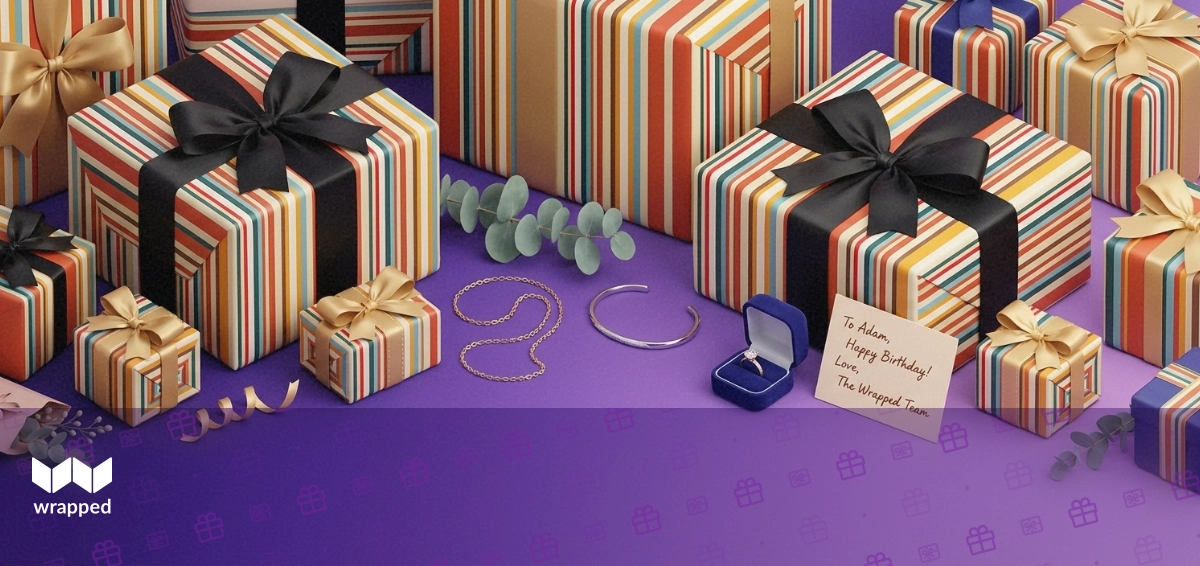A gold necklace, silver bracelet and velvet ring box arranged with eucalyptus and a handwritten gift card