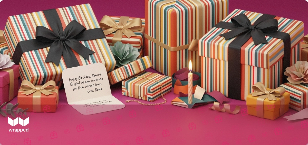 Gold bracelet, striped gift box, lit birthday candle and a handwritten card arranged on a bright magenta editorial surface