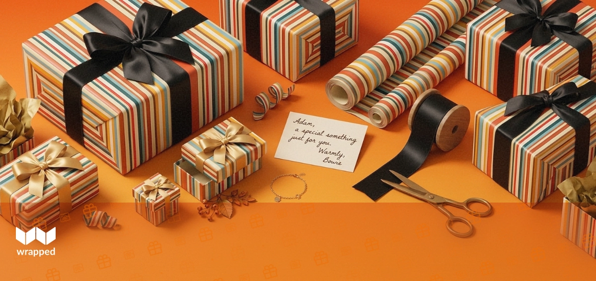 Patterned wrapping paper, satin ribbon, brass scissors and a gold bracelet arranged on a warm amber autumn table