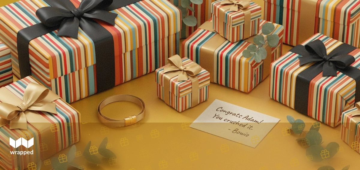 Editorial still life with a gold ribbon bracelet, small gift box, handwritten congratulations card and eucalyptus sprig