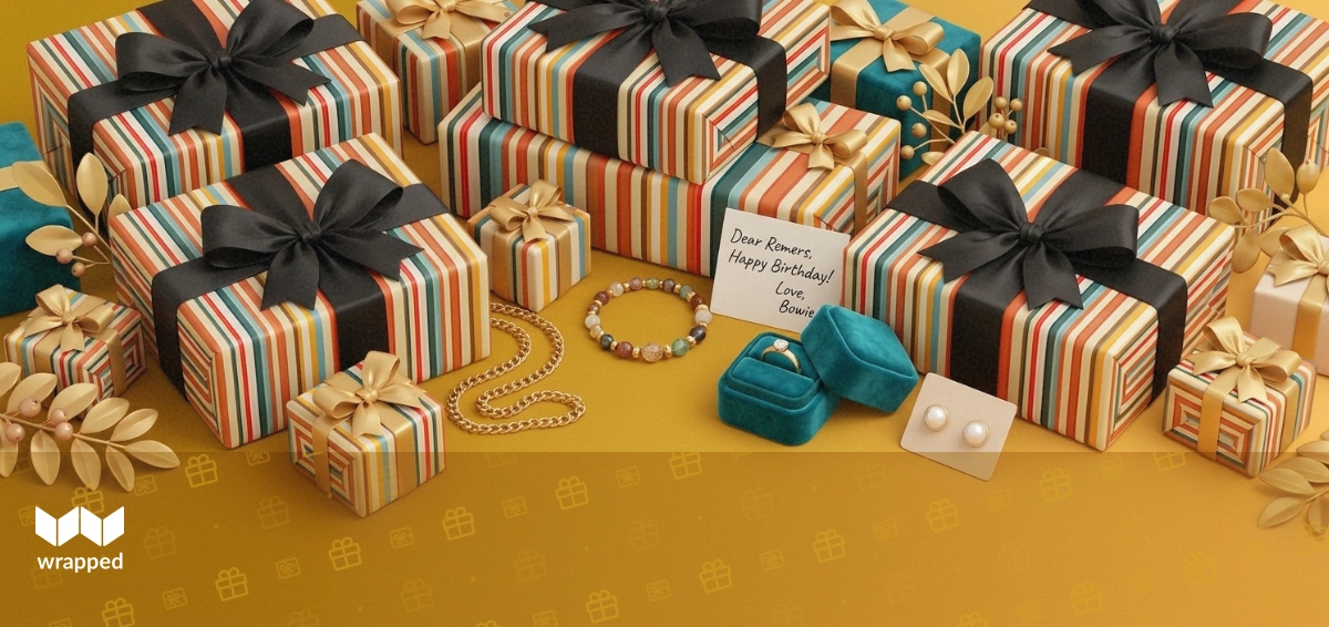 A gold chain necklace, beaded bracelet, velvet ring box and pearl earrings arranged beside a handwritten gift card
