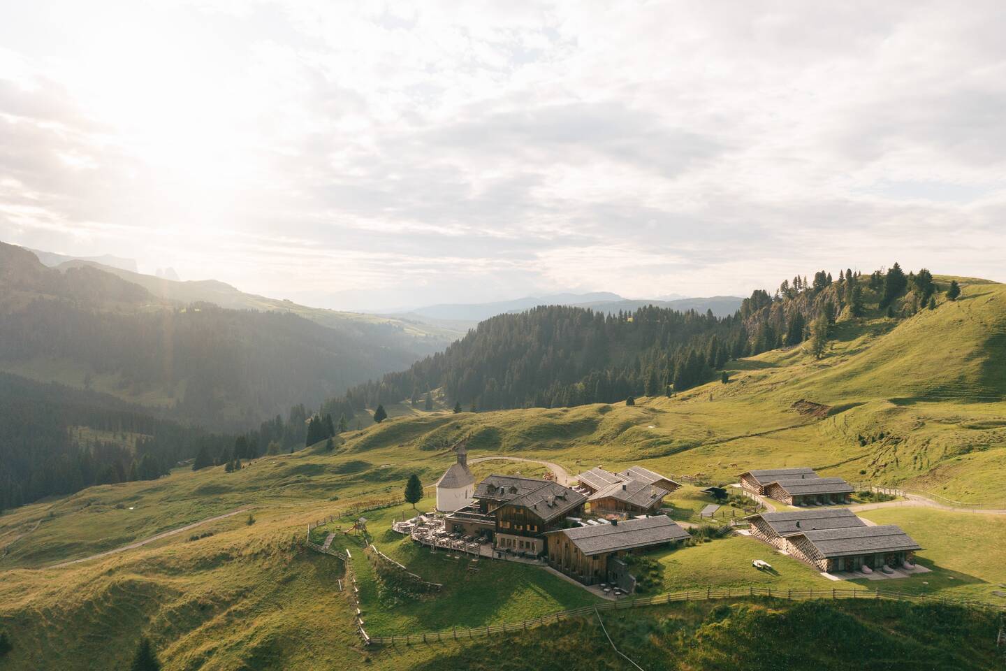 The Zallinger hamlet on the Alpe di Siusi, chapel and restored wooden huts in evening light