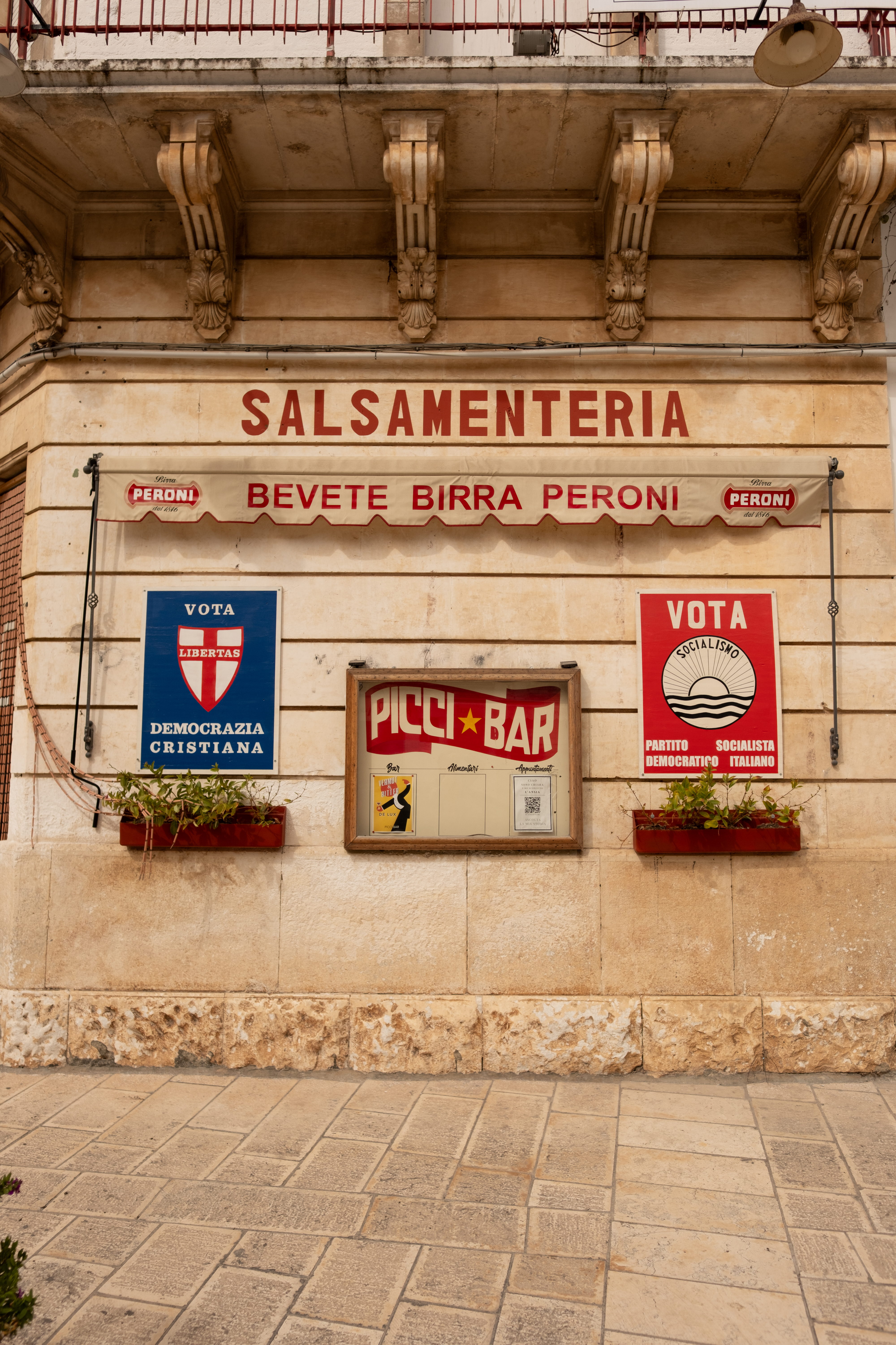 Picci Bar, Carovigno — Salsamenteria facade with vintage Peroni awning and election posters