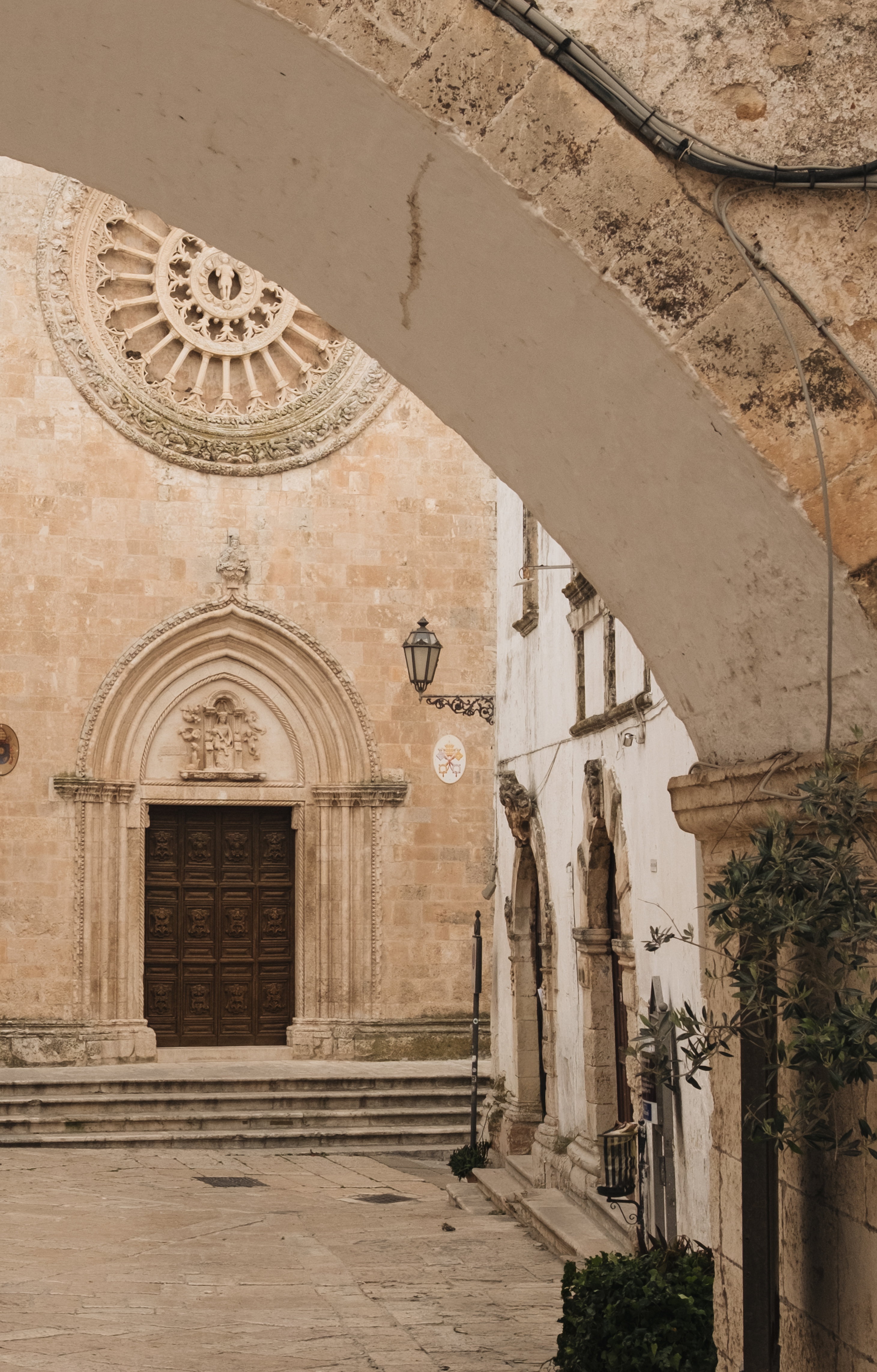 Ostuni cathedral seen through a stone arch in the old town