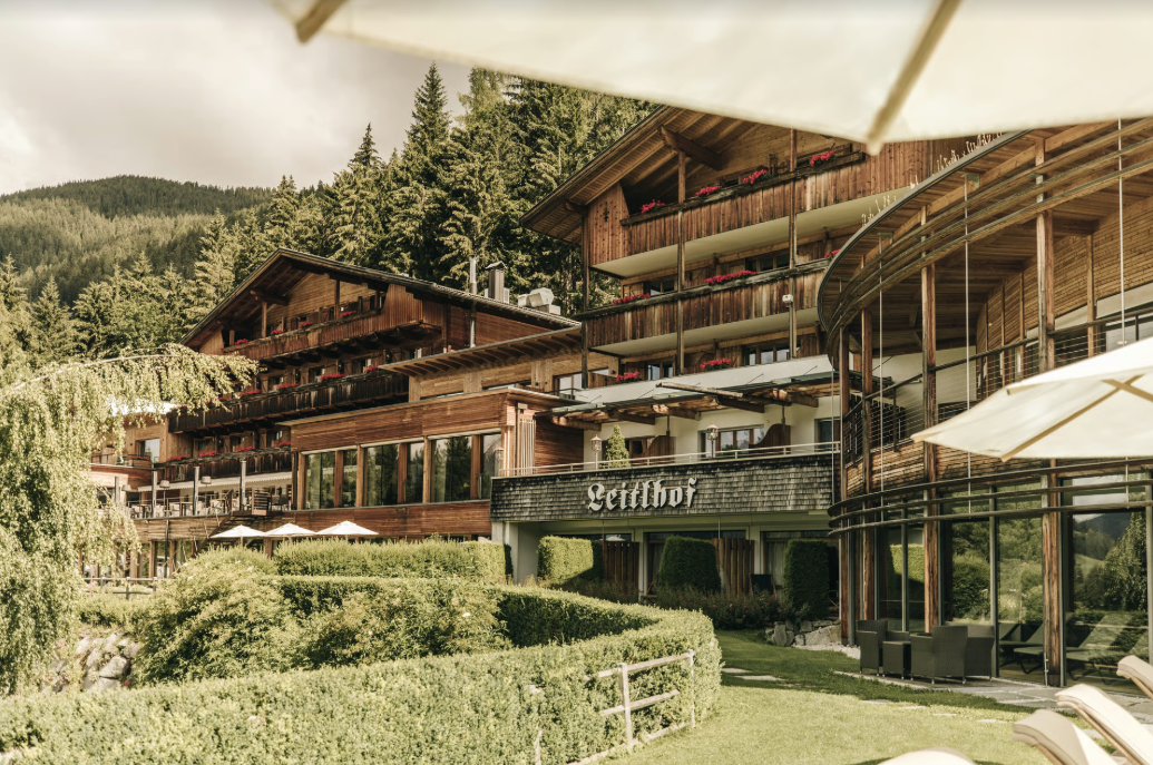 The Leitlhof above Innichen seen from its garden, larch balconies and spruce forest behind