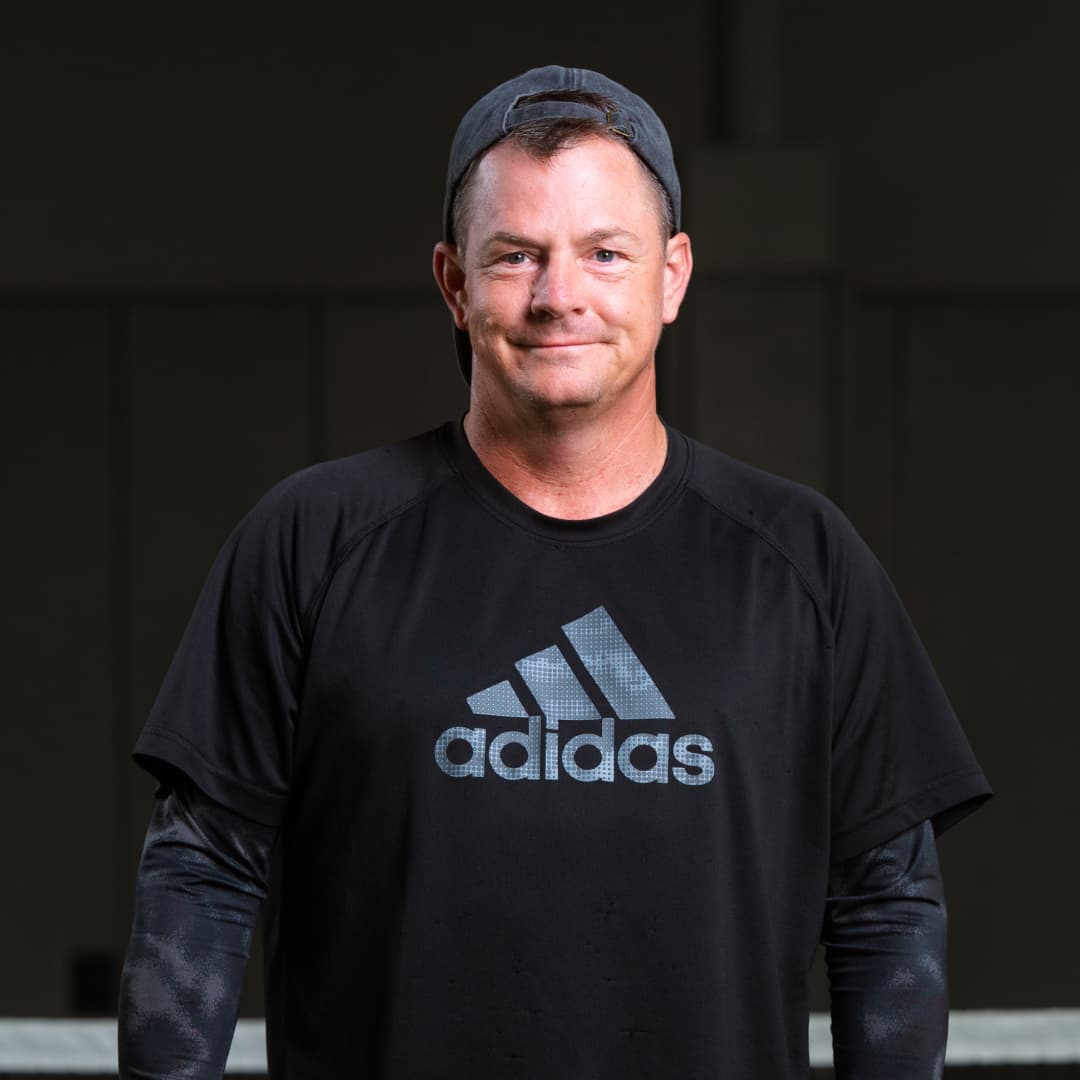 Profile picture of Chris Wilton wearing a black hat and black Adidas branded shirt.