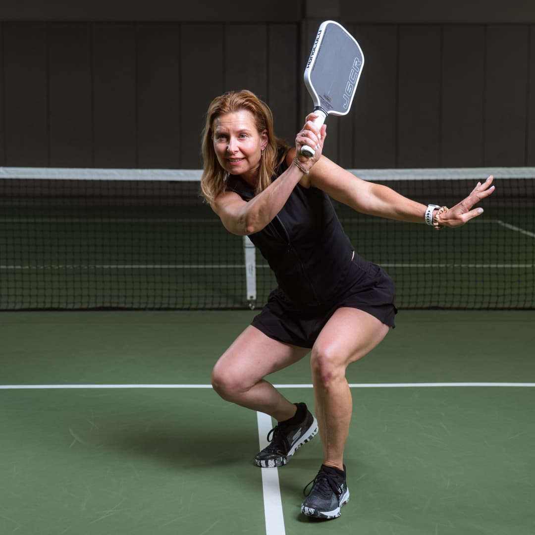 Profile picture of Cindy Kresch wearing a black sleeveless shirt and skirt crouching in an action pose.