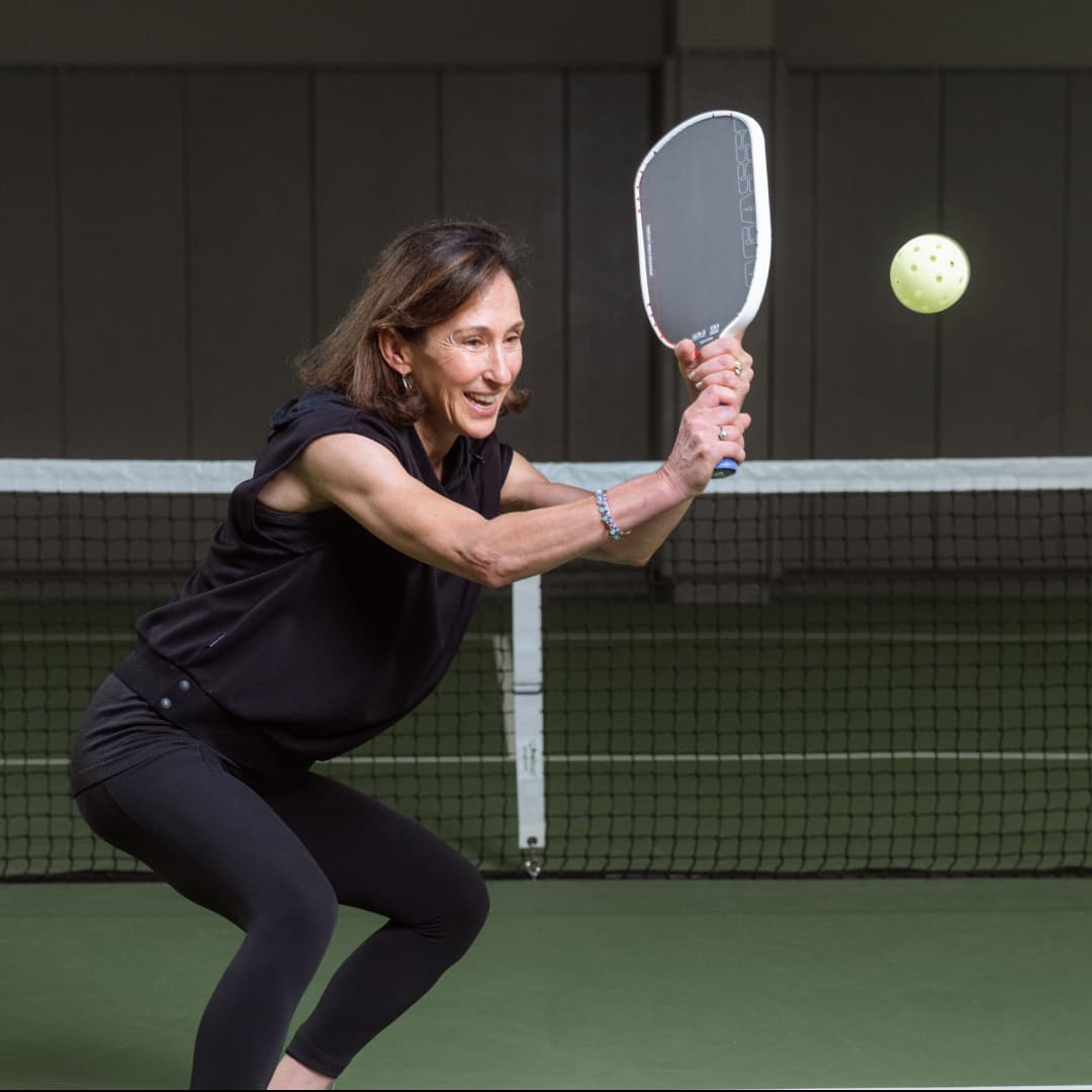 Profile picture of Natalia Garcia Miller wearing a black sleeveless polo crouched in a action pose.