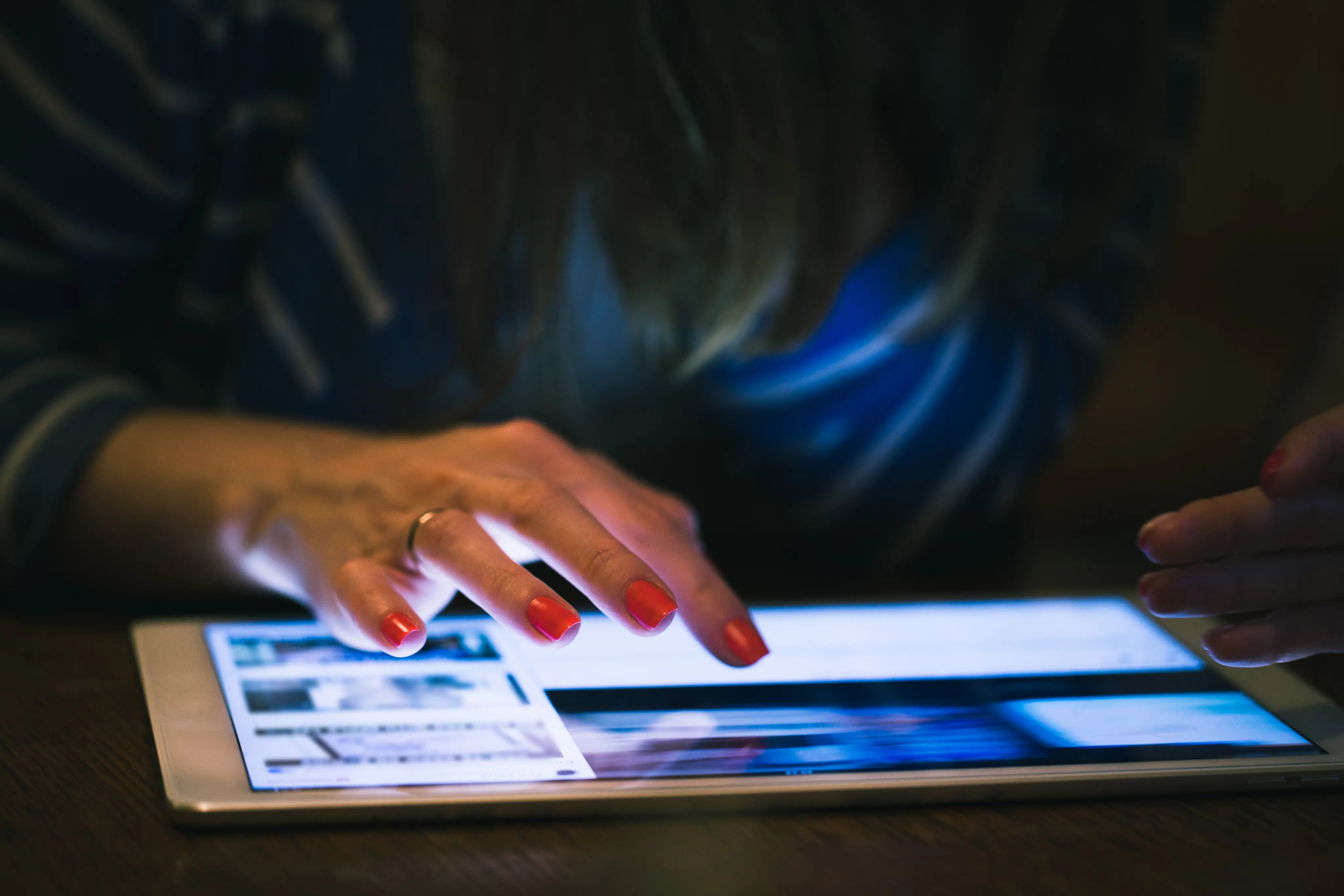 Hand using a tablet in a dark room