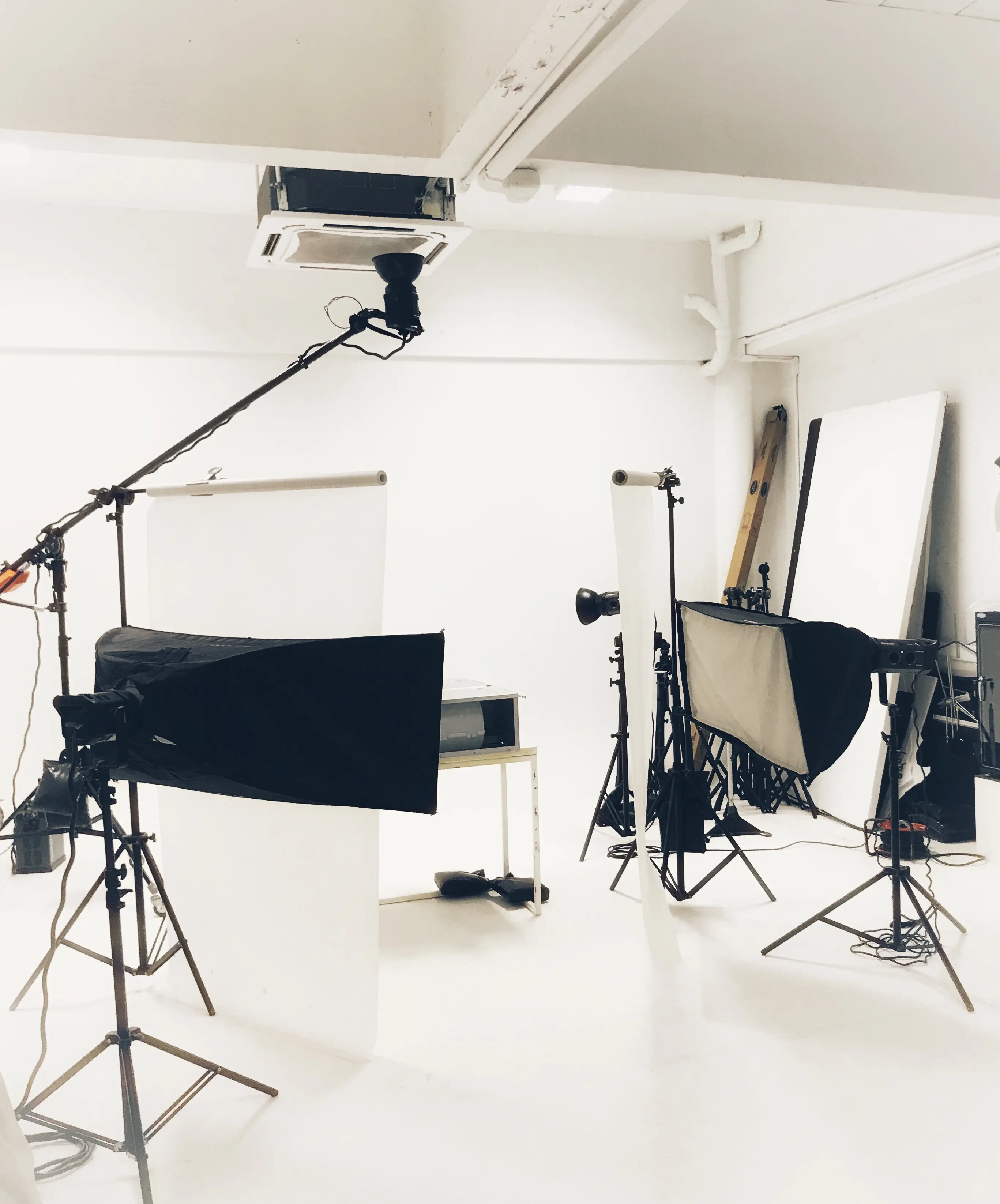 An empty photography studio set with softbox lighting equipment on stands.