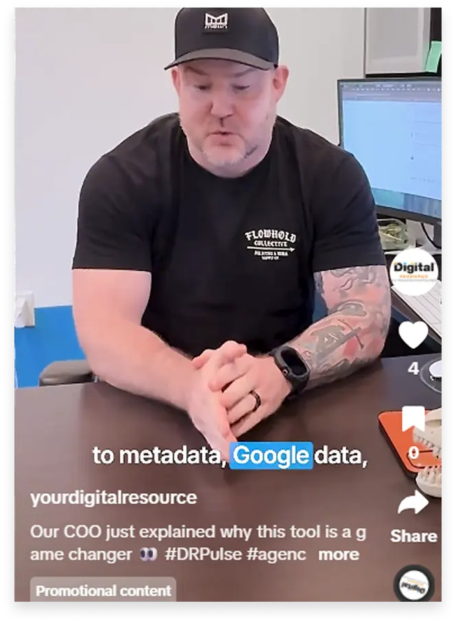 A man wearing a black Flowhold Collective t-shirt and a black cap with a logo is speaking while sitting at a desk. He has a tattoo on his left arm and is wearing a black smartwatch. A computer monitor is visible behind him. Text overlay on the image includes 'to metadata, Google data,' and a caption mentioning the COO explaining why a tool is a game changer. The image appears to be a promotional video or social media post.