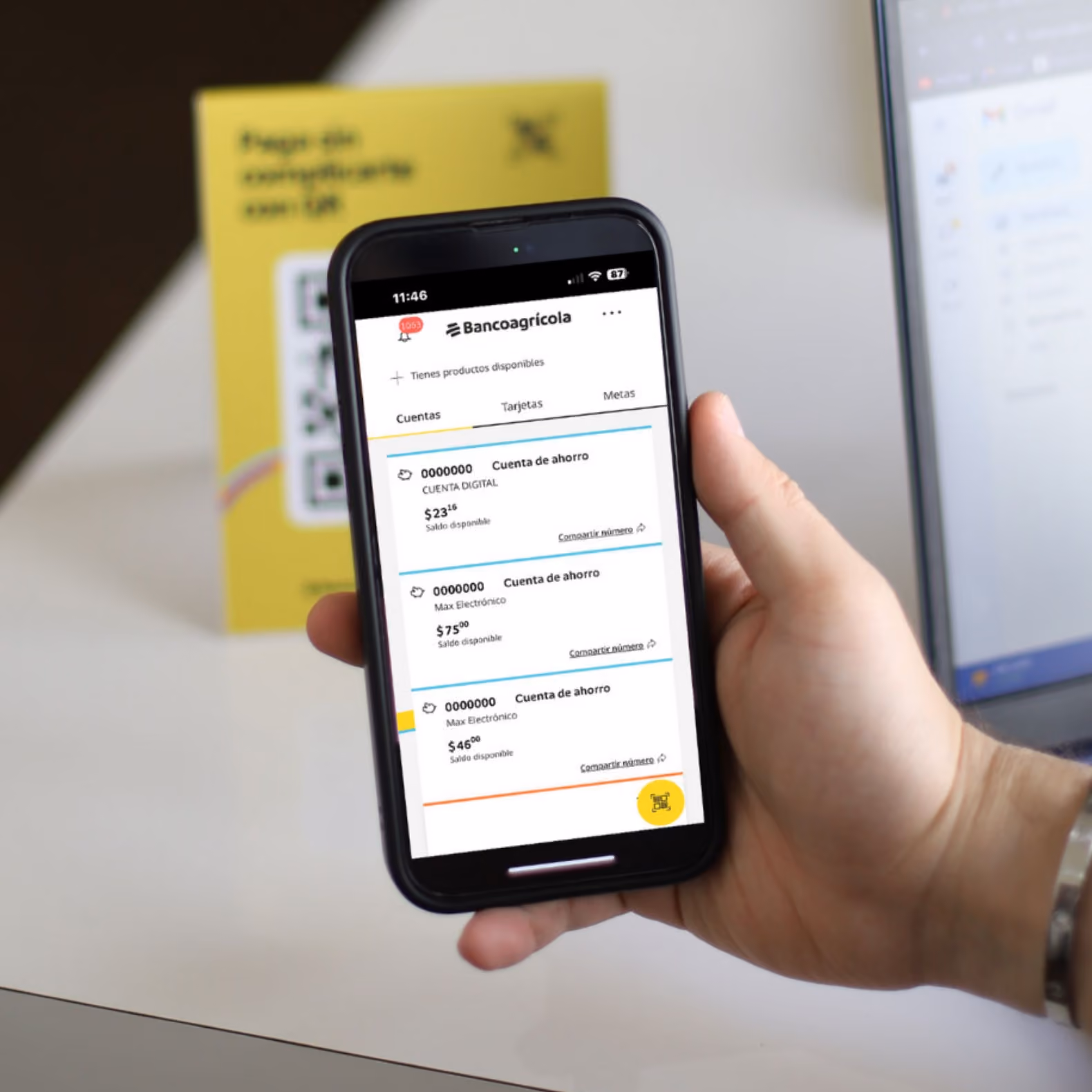 Mano sosteniendo un celular con la aplicación Bancoagrícola abierta mostrando cuentas de ahorro.