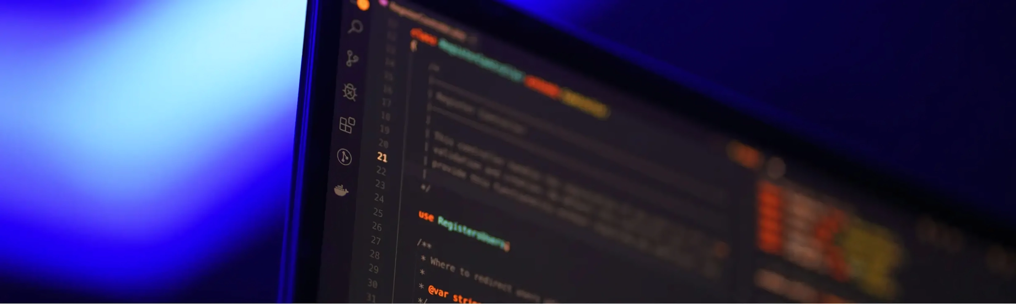 Pantalla de computadora con código de programación y fondo azul desenfocado.